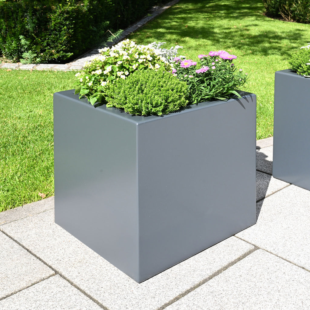 Bepflanzter grauer Pflanzkübel Clarus im grünen Garten