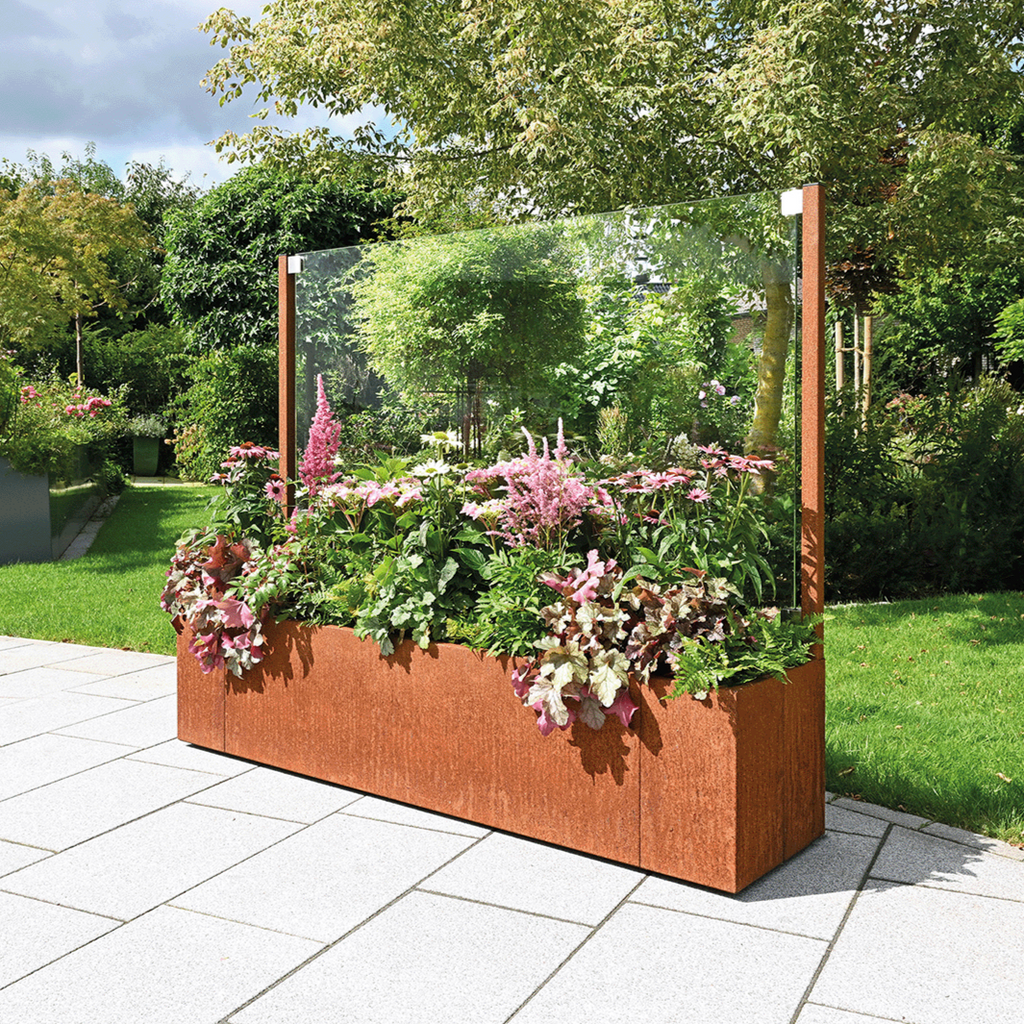 Cortenstahl Pflanzkasten in Kombination mit Windschutz mit Glasscheibe bepflanzt auf der Terrasse