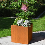 Pflanzkübel aus Cortenstahl im Garten mit Blumen bepflanzt