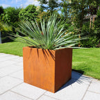 Pflanzkasten Basio aus Cortenstahl bepflanzt auf der Terrasse im Garten