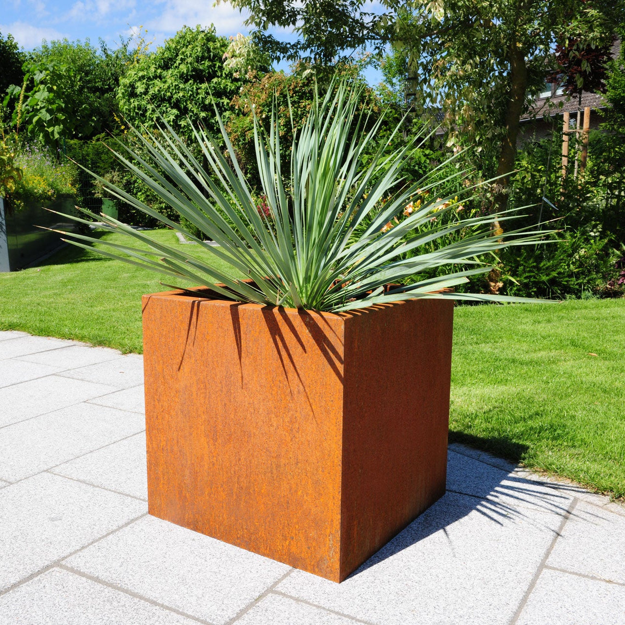 Pflanzkasten Basio aus Cortenstahl bepflanzt auf der Terrasse im Garten