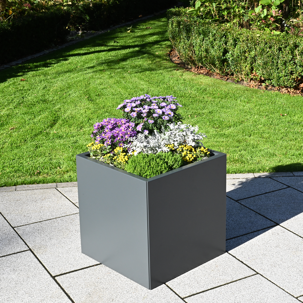 Grauer Aluminium-Pflanzkasten Duplex mit bunten Blumen auf einer Terrasse vor dem Garten