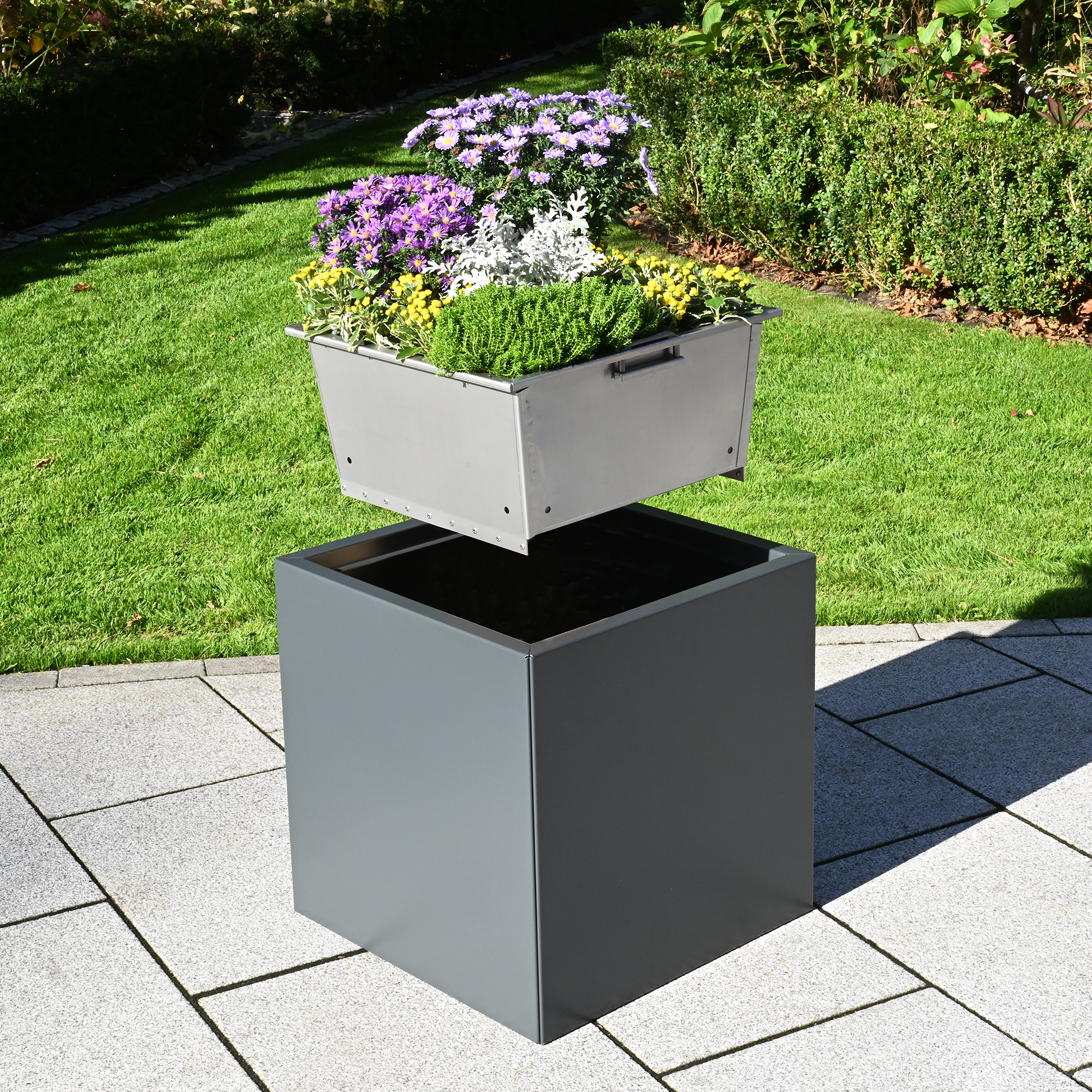 Entnehmbarer Trog beim Pflanzkasten Duplex schwebt über dem grauen Pflanzkasten aus Aluminium